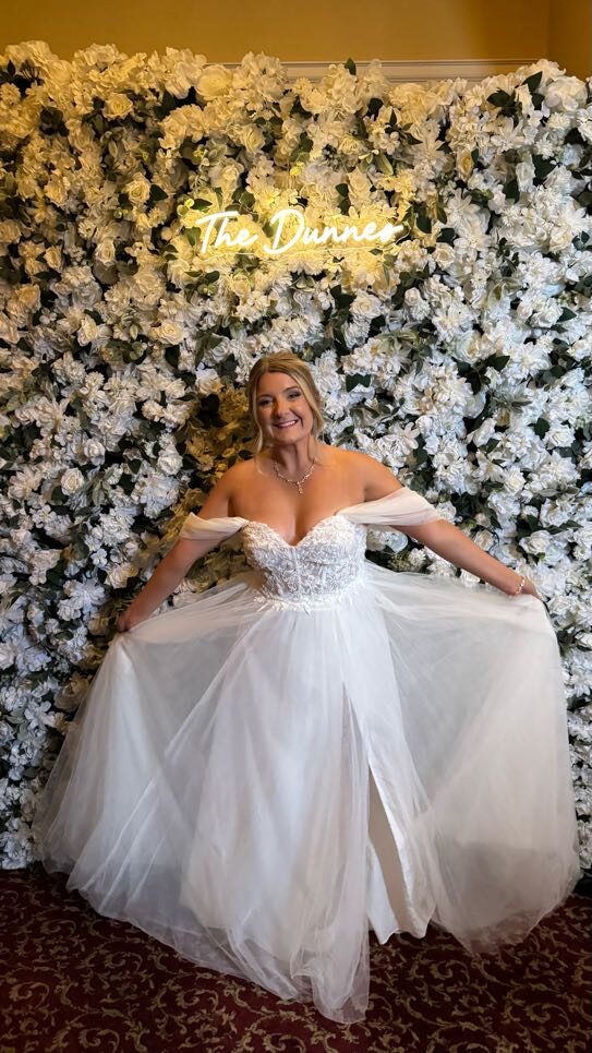 Bride in front of white flower wall photo backdrop rental